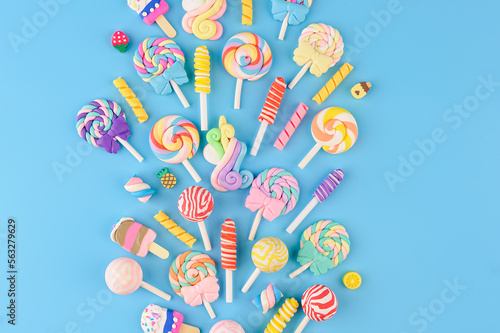 Explosion of decorative candies, lollipops and ice cream. Top view on blue background