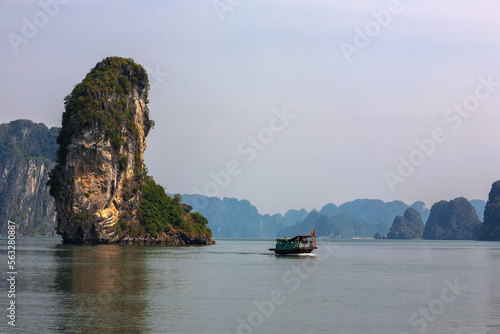 A local boat passes Ngon Tay Islet in the channel north-east of Cat Ba Island, Ha Long Bay, Quang Ninh, Viet Nam