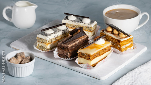 A set of delicious cakes and coffee on a light table