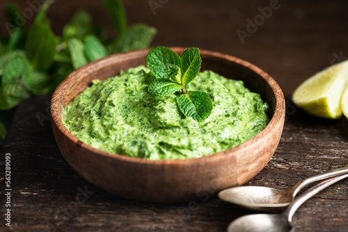 Foto Indian green chutney in a wooden bowl , selective focus