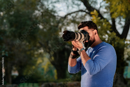 Young indian man using camera equipment at park