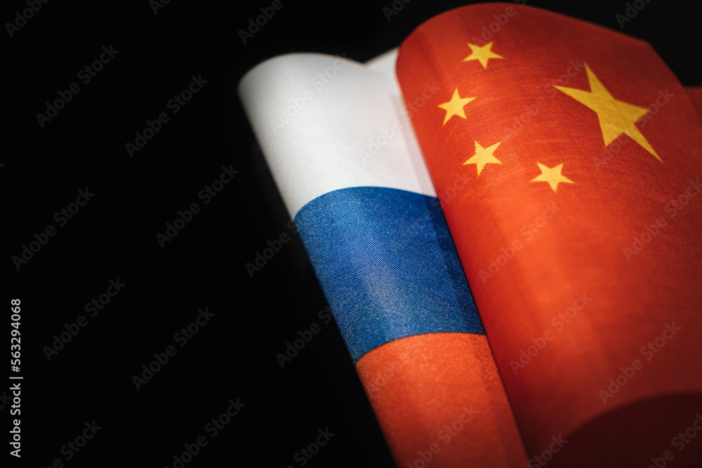 flags of the China and russia on a black background. The concept of interaction or counteraction between the two countries. International relations. political negotiations. copy space. - obrazy, fototapety, plakaty 