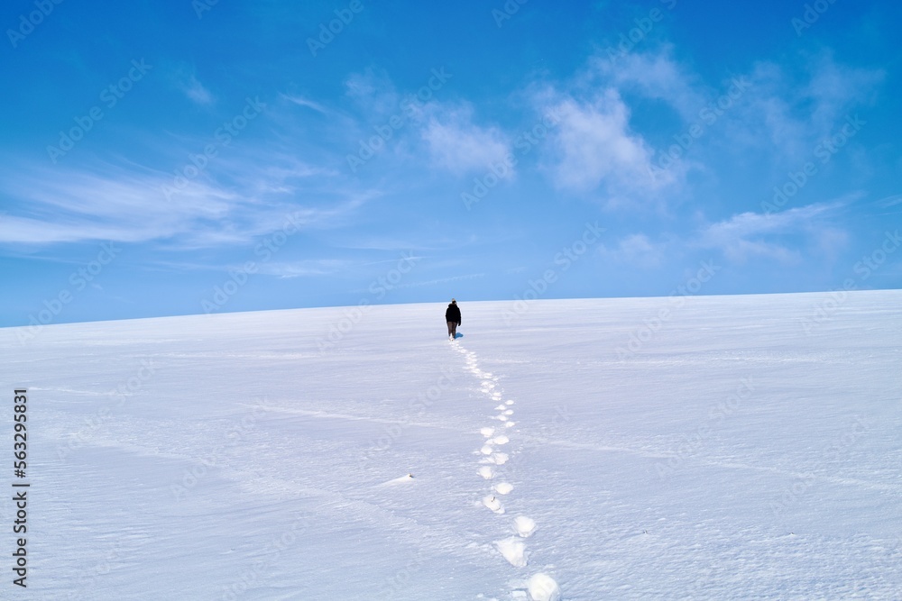 person leaving behind a track in the  snow 