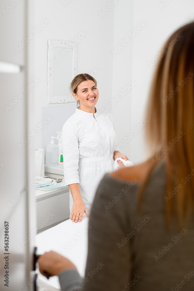 Fototapeta premium Focus on smiling woman beautician in beauty parlor