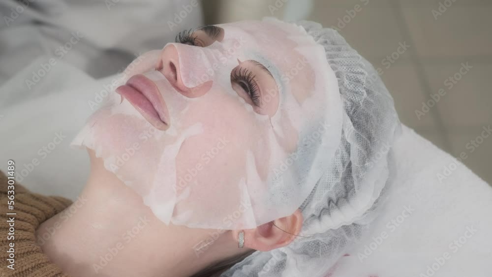 Professional puts face mask to woman client. Cosmetology. Professional puts face mask to woman client. Cosmetology.
