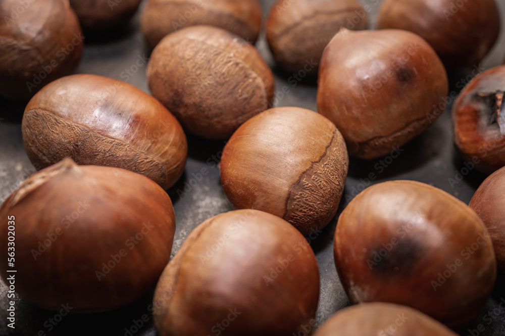 Roasted chestnuts on a dark surface background. Close up view Roasted chestnuts on a dark surface background. Close up view