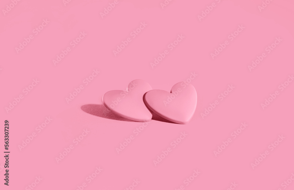 two pink hearts on pink background. Minimal monochrome for St Valentines day or 14 February. Mothers Day or wedding invitation