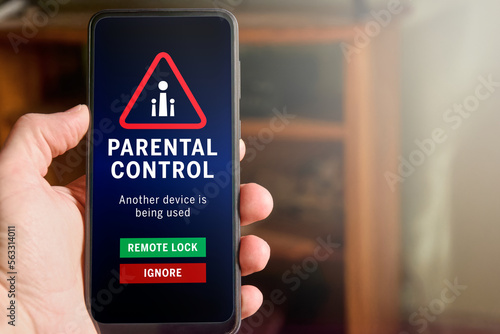 Male hand holding mobile phone with parental control warning on the screen: 
