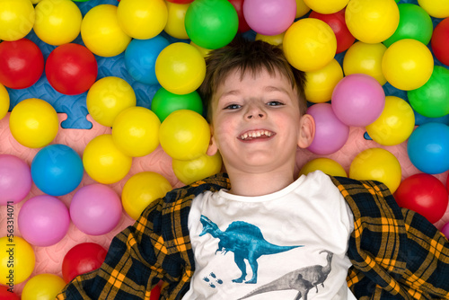 joyful boy among colored balloons