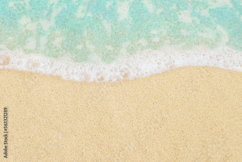 Soft ocean wave on beach background in top view. Blue sea water and textured sand close-up with copy space for text and design