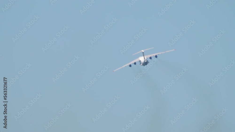 Heavy transport four-engine aircraft climb after takeoff, rear view ...