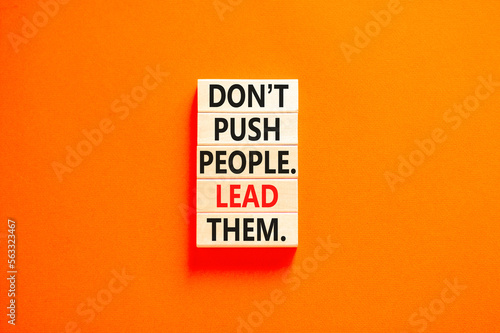 Push or lead people symbol. Concept words Do not push people lead them on wooden blocks. Beautiful orange table orange background. Business Push or lead people concept. Copy space.
