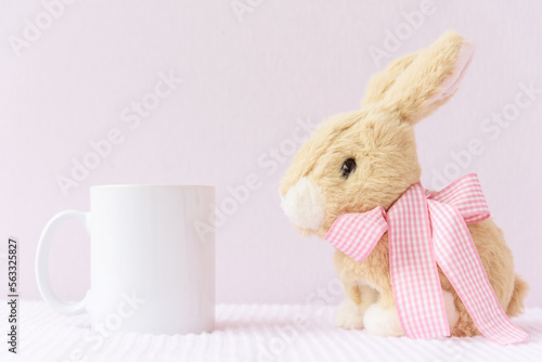 Easter mockup white blank mug with rabbit on pink cover background, copyspace. photo