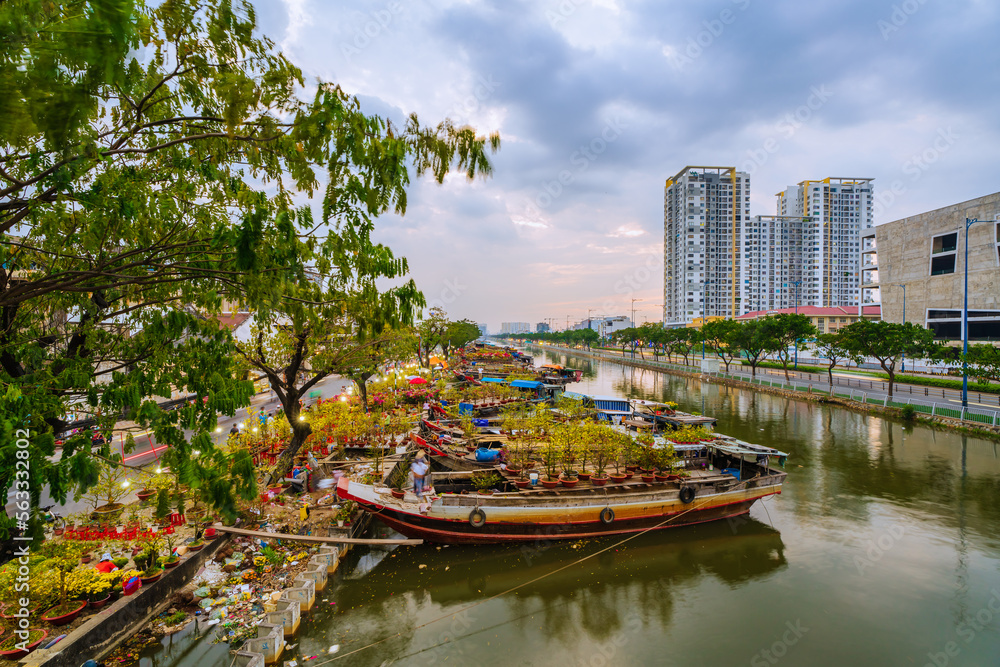 Springtime in Saigon, boat on canal, transport spring flower for Tet to Ben Binh Dong open air market, Vietnamese happy with Lunar New Year, Vietnam