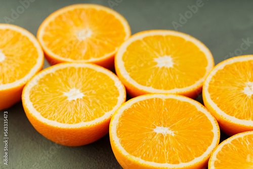 Halves of juicy oranges on a green background. Half cut oranges for making juice. Close up