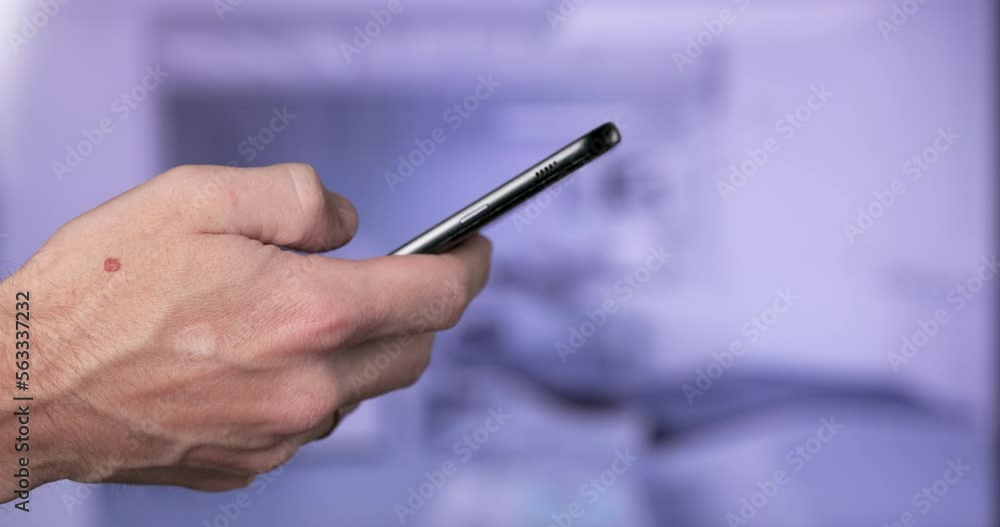 A man's Hand with a Phone close-up on the background of the Office or Clinic. Using modern Digital Technology. A man's Hand with a Phone close-up on the background of the Office or Clinic. Using modern Digital Technology.