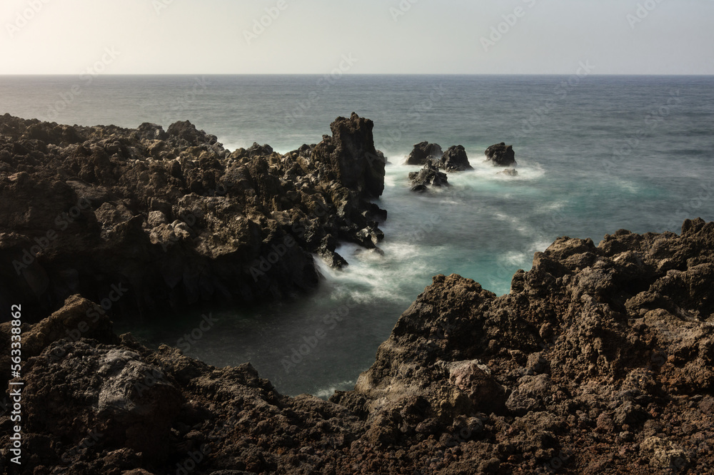 Rocky, volcanic coastline at sunset over the Atlantic Ocean