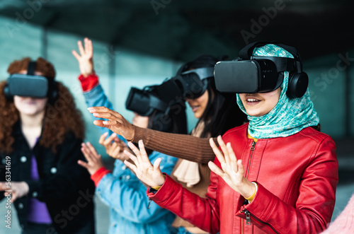 Young multiracial girls using futuristic virtual reality glasses - Technology and metaverse concept