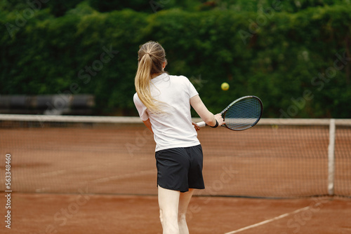 Backside photo of female tennis player on a tennis court