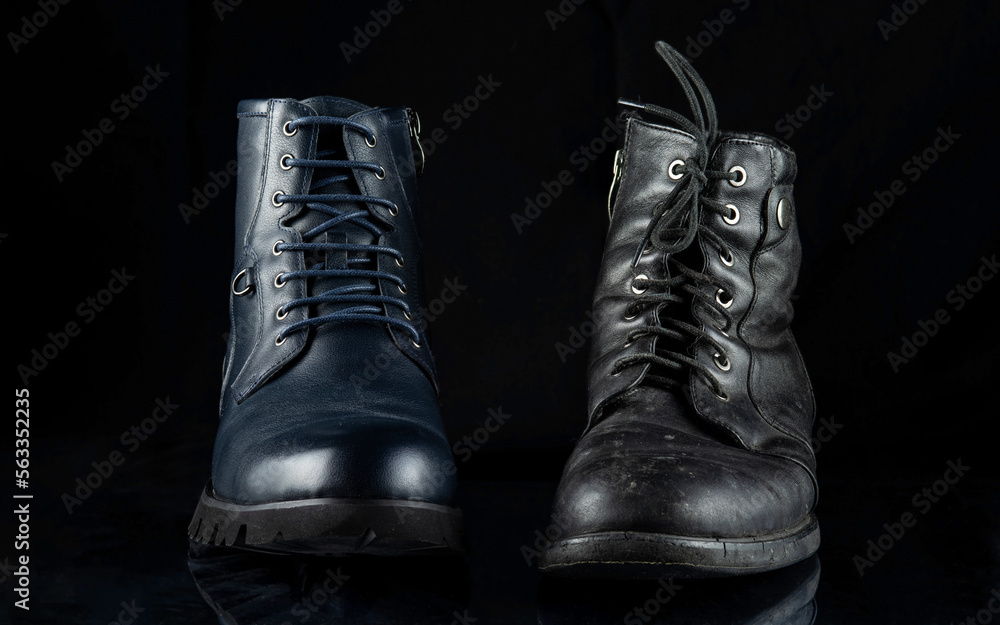A pair of men's shoes - new and old. Isolated on a black background.