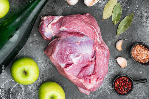 Raw pork meat and ingredients for roast, with apple dry cider, on black dark stone table background, top view flat lay photo