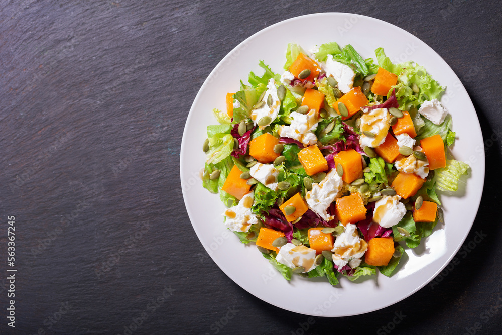 plate of salad with baked pumpkin and cream cheese, top view plate of salad with baked pumpkin and cream cheese, top view