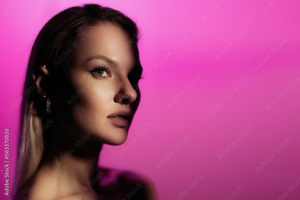 Fashion woman profile portrait on pink gradient background with soft light play on skin. Lights play. Fashion woman profile portrait on pink gradient background with soft light play on skin. Lights play.