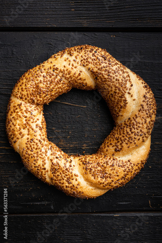 Bagel is traditional Turkish bakery food simit gevrek, on black wooden table background, top view flat lay