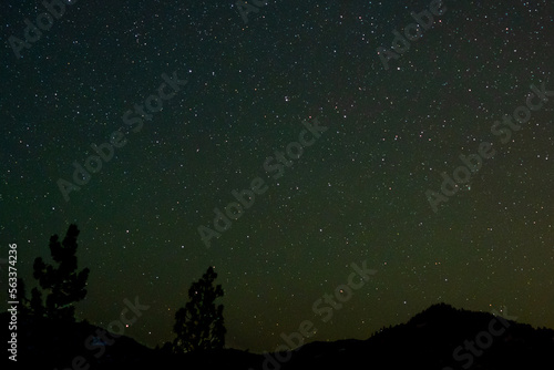 Rare green comet C/2022 E3 (ZTF) begins to appear in an ocean of green aurora as seen from southern Oregon just north of the California border.