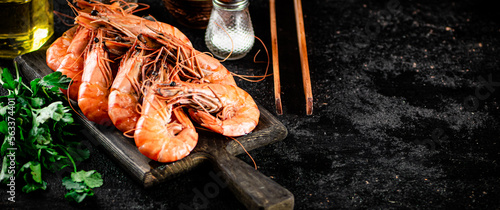 Boiled shrimp on a cutting board with parsley and spices. 