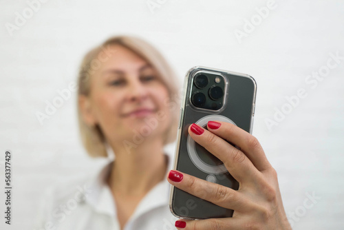  a cute young woman holding a phone and making photo 