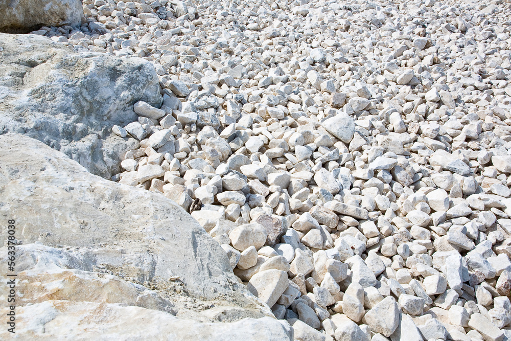 Expanse of white different sizes gravel in a construction site used in the construction industry and building activity for the construction of roadbeds Expanse of white different sizes gravel in a construction site used in the construction industry and building activity for the construction of roadbeds