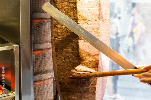 Cutting with knife doner traditional turkish Doner Kebab meat. Turkish cuisine street food in Istanbul, Turkey.