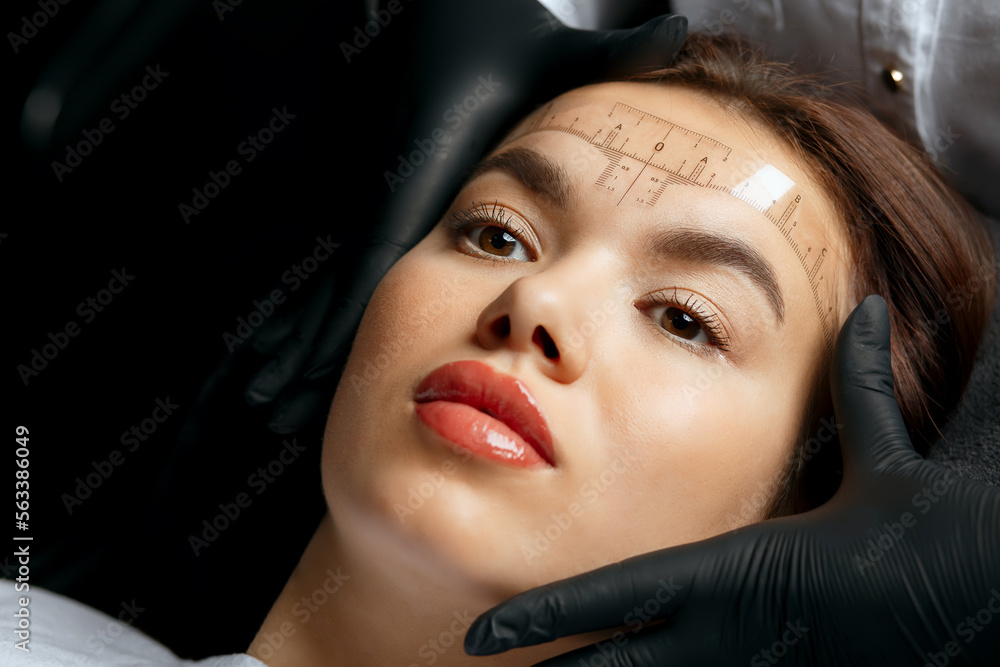 Brow master measuring the angle of eyebrows with a ruler Brow master measuring the angle of eyebrows with a ruler