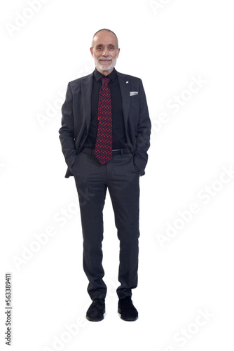 front view of a man standing with suit and looking at camera and hands on pockets on white background © curto