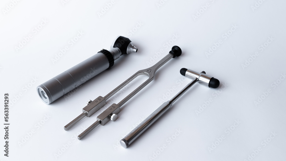 tuning fork C 128 on a white background with gradation and otorhinoscope and neurological hammer tuning fork C 128 on a white background with gradation and otorhinoscope and neurological hammer