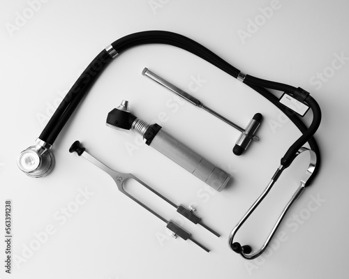 tuning fork C 128 on a white background with gradation, otorhinoscope, neurological hammer and stethoscope