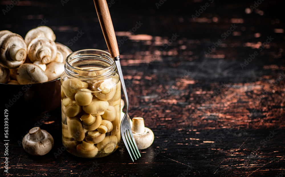 Pickled mushrooms in a glass jar on the table. Pickled mushrooms in a glass jar on the table.
