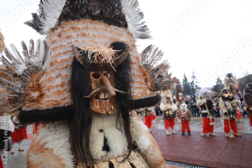 Breznik, Bulgaria - January 21, 2023: Unidentified people with traditional Kukeri costume are seen at the Festival of the Masquerade Games Surova in Breznik, Bulgaria photo