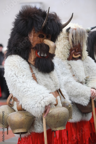 Breznik, Bulgaria - January 21, 2023: Unidentified people with traditional Kukeri costume are seen at the Festival of the Masquerade Games Surova in Breznik, Bulgaria photo