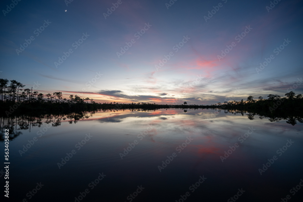 Colorful twilight cloudscape over and reflected in Pine Glades Lake in Everglades National Park, Florida..