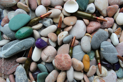 Closeup of unitary cartridges partially covered with colored smooth stones photo
