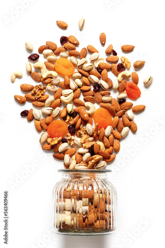 Dried fruits and nuts mixed and glass jar. Concept of the Jewish holiday Tu Bishvat on white background with copy space