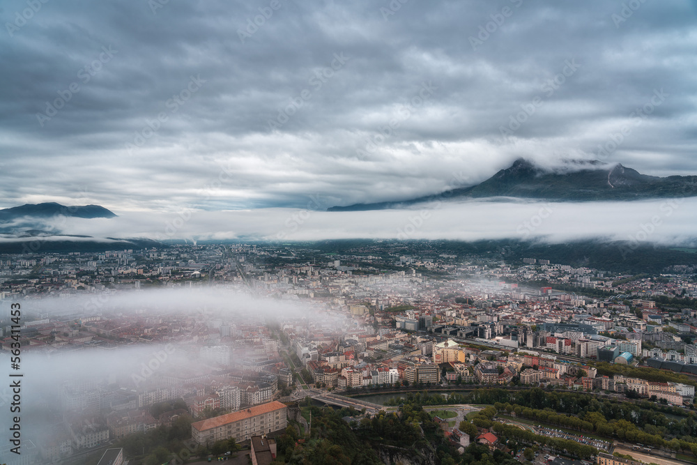 Grenoble cityscape, aerial view of Grenoble city with clouds and mountain background