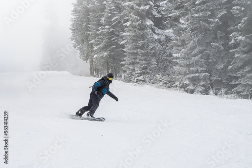 Snowboarder riding on the ski slope.