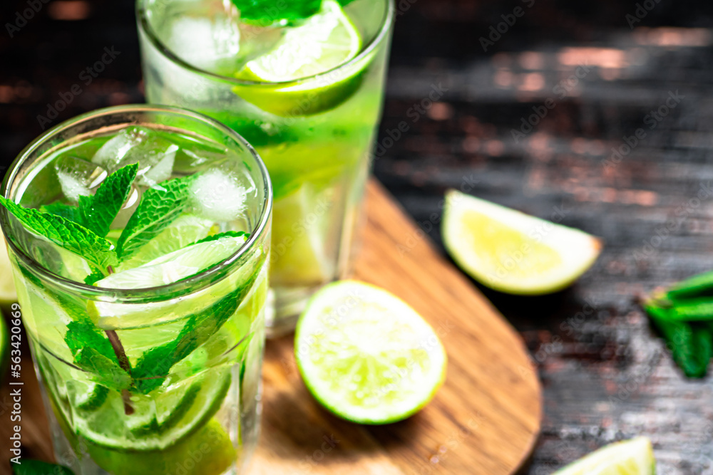 Mojito with pieces of lime on a cutting board. Mojito with pieces of lime on a cutting board.