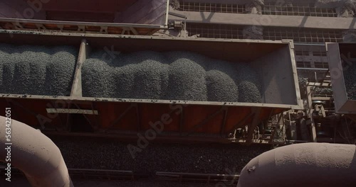 Aerial view of cargo train loaded with crushed stone materials at mining factory. Railway transportation of grinded limestone ore