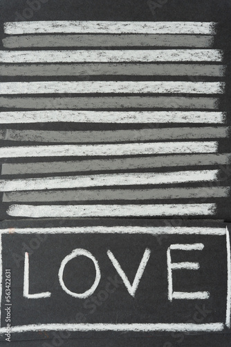 the word "love" in white chalk on black paper with horizontal stripes