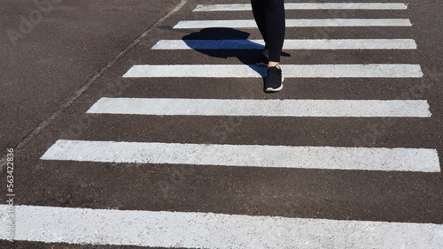 Pedestrian crosses the street at the pedestrian crossing.