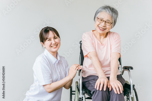 シニア・高齢者女性と話す介護士・看護師・理学療法士・ヘルパーのアジア人女性 